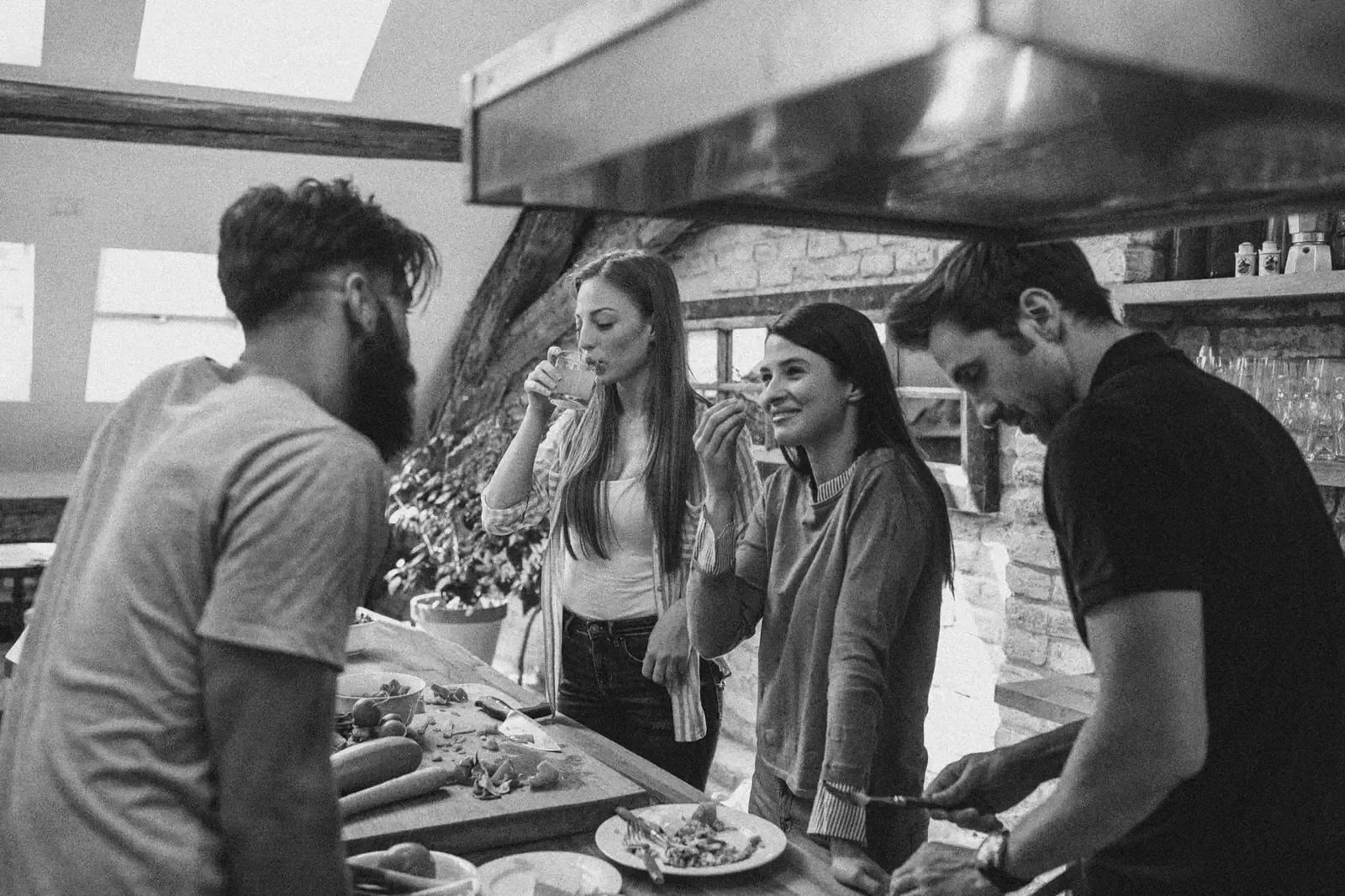 Freunde kochen und genießen gemeinsam an einer Kücheninsel